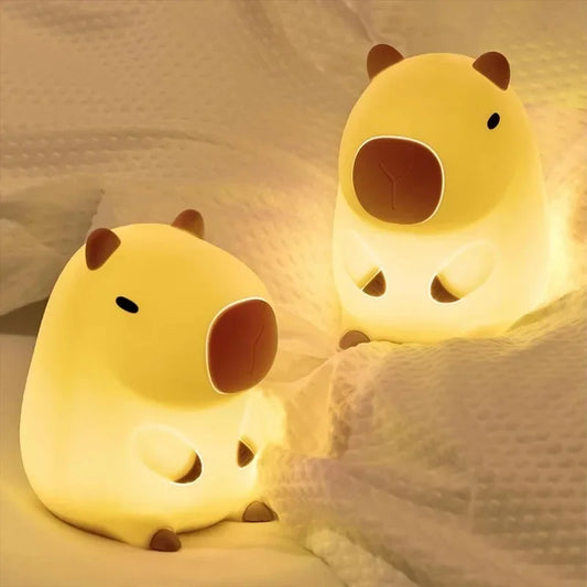 Imagem de dois abajures em formato de capivaras fofas, com luz quente, decorativos e aconchegantes, perfeitos para quarto infantil ou sala de estar.
