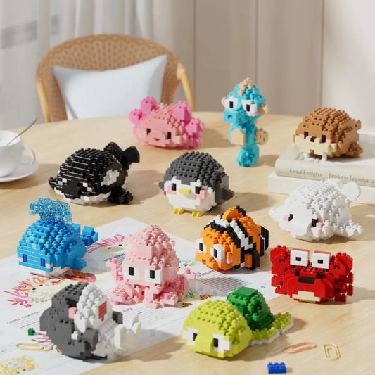 Coleção de criaturas marinhas e personagens de desenho feitas com blocos de montar em uma mesa de madeira, incluindo peixe, polvo, peixe-palhaço, tartaruga, pinguim, cavalo marinho e outros.