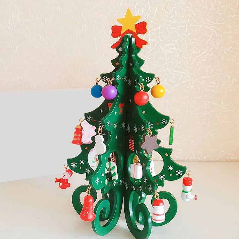 Mini árvore de Natal decorativa verde com pequenos enfeites coloridos, laço vermelho, estrela dourada na ponta e pacote de presentes, ideal para decoração natalina de mesa.