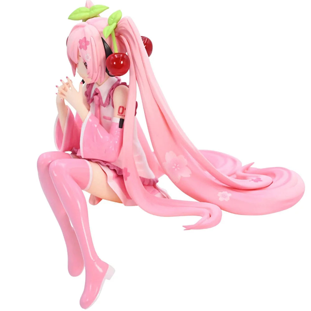 Figura de uma personagem de anime com cabelo rosa, vestido rosa e chapéu decorado com cerejas, em pose de oração, sentada com uma expressão delicada.